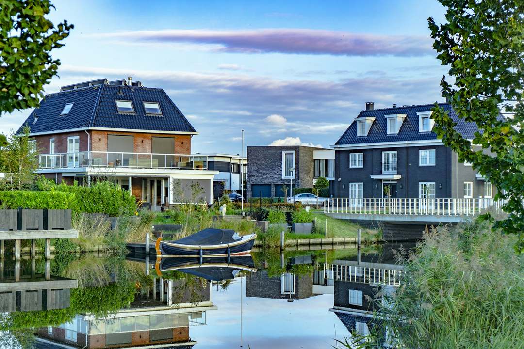 Nieuwe vrijstaande woningen aan het water in een Nederlandse woonwijk